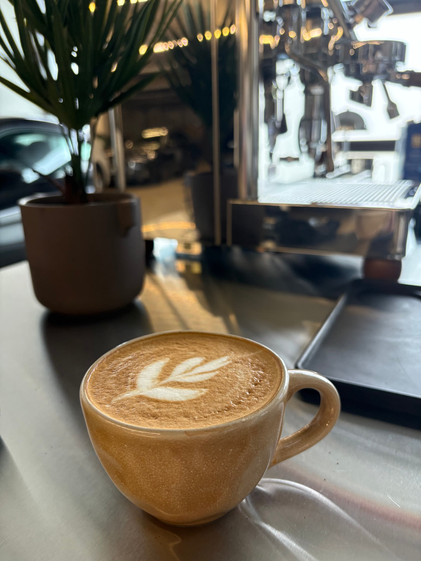 Cappuccino mit Latte Art vor der Espressomaschine
